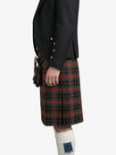 Person wearing a black jacket and red plaid kilt on a white background