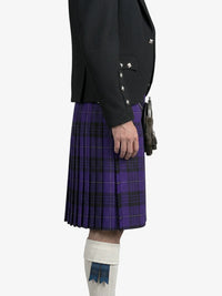 Person wearing a black jacket and purple plaid kilt on a white background