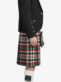 Person wearing a black blazer and a plaid kilt on a white background