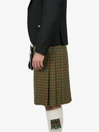 Person wearing a black jacket and green plaid kilt on a white background