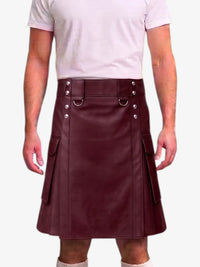 A person wearing a dark burgundy faux-leather kilt with silver-tone metal hardware, belt loops, and side pockets, paired with a light pink t-shirt against a plain white background.