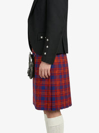 Person wearing a black jacket and red plaid kilt on a white background
