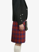 Person wearing a black blazer and red plaid kilt on a white background