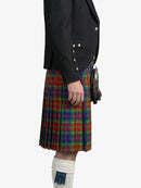 Person wearing a black jacket and a colorful plaid kilt on a white background