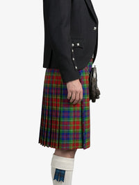 Person wearing a black jacket and a colorful plaid kilt on a white background