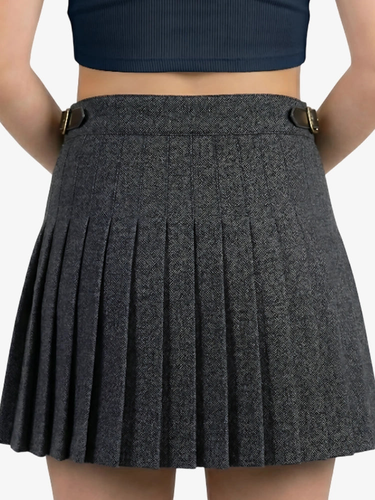 Gray pleated skirt worn by a person on a plain background