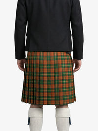 Person wearing a black jacket and green plaid kilt on a white background