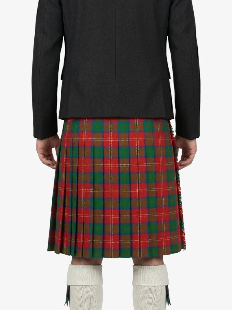 Person wearing a black jacket and red plaid kilt on a white background