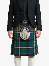 Person wearing a black suit with a green plaid kilt on a white background