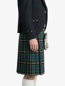 Person wearing a dark jacket and a plaid kilt on a white background