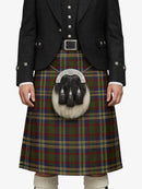 Person wearing a traditional Scottish kilt with a tartan pattern on a white background