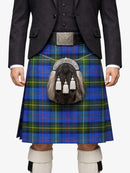 Person wearing a traditional Scottish kilt with a tartan pattern on a white background