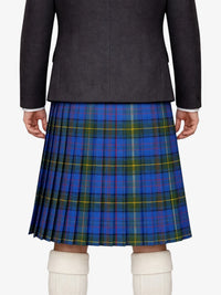 Person wearing a dark jacket and blue plaid kilt on a white background