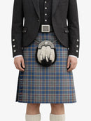 Person wearing a traditional Scottish kilt with a jacket on a white background