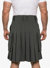 Person wearing a gray pleated kilt on a white background