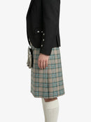 Person wearing a black jacket and plaid kilt on a white background