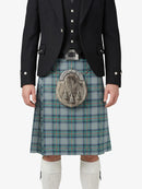 Person wearing a traditional Scottish kilt with a tartan pattern on a white background