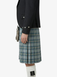 Person wearing a black blazer and plaid kilt on a white background