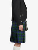 Person wearing a black blazer and a plaid kilt on a white background