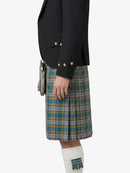 Person wearing a black jacket and plaid kilt on a white background
