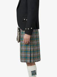 Person wearing a black jacket and plaid kilt on a white background