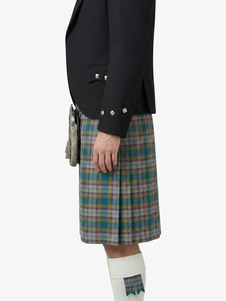Person wearing a black jacket and plaid kilt on a white background