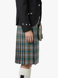 Person wearing a black jacket and plaid kilt on a white background