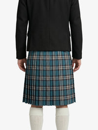 Person wearing a black jacket and blue plaid kilt on a white background
