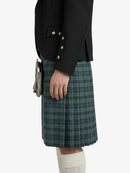 Person wearing a black jacket and green plaid kilt on a white background