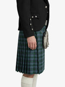 Person wearing a black jacket and green plaid kilt on a white background