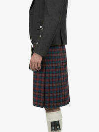 Person wearing a dark gray jacket and red plaid kilt on a white background