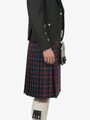 Person wearing a dark jacket and red plaid kilt on a white background