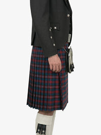 Person wearing a dark jacket and red plaid kilt on a white background