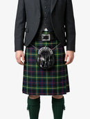 Person wearing a traditional Scottish kilt with a tartan pattern on a white background