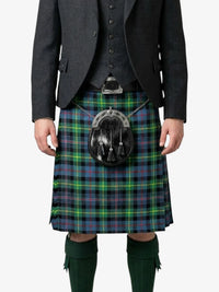 Person wearing a traditional Scottish kilt with a tartan pattern on a white background