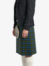 Person wearing a dark jacket and green plaid kilt on a white background