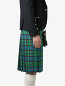 Person wearing a black jacket and green plaid kilt on a white background