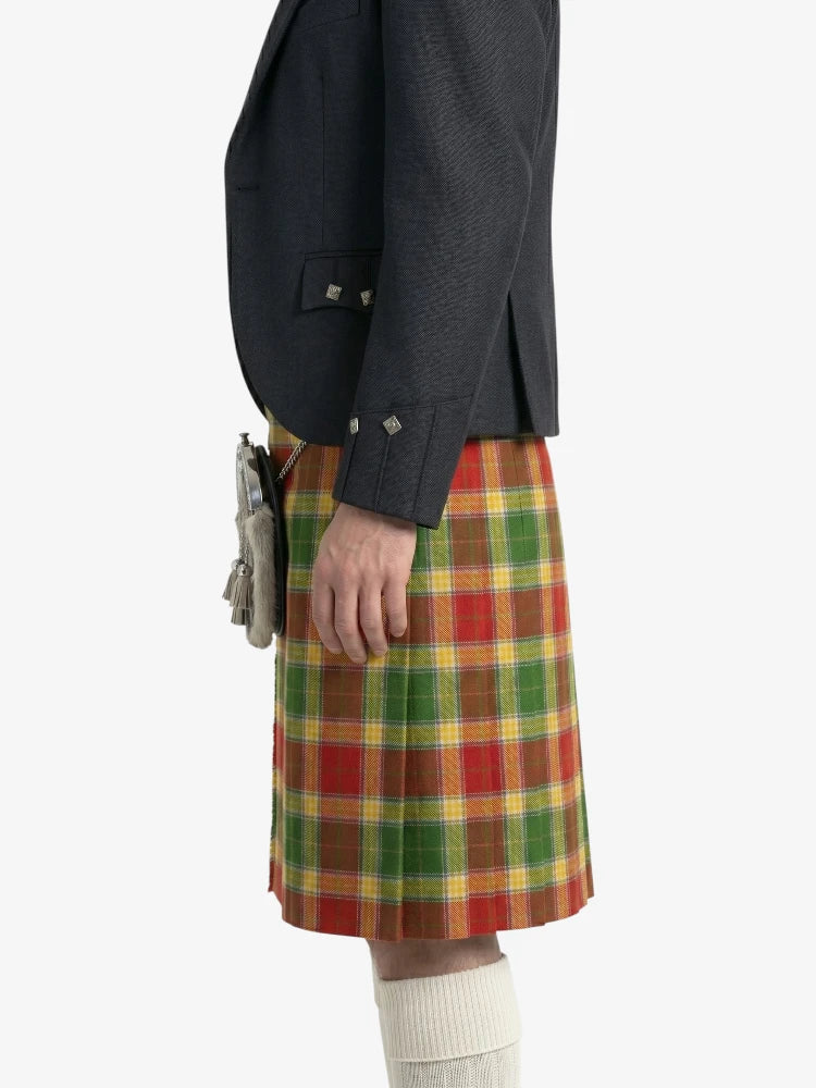 Person wearing a dark jacket and plaid kilt on a white background