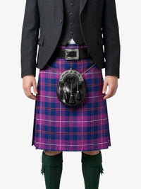 Person wearing a traditional Scottish kilt with a tartan pattern on a white background
