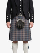 Person wearing a traditional Scottish kilt with a jacket on a white background