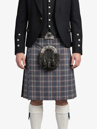 Person wearing a traditional Scottish kilt with a jacket on a white background