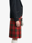 Person wearing a black jacket and red plaid kilt on a white background