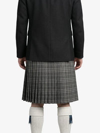 Person wearing a black coat and plaid kilt on a white background