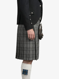 Person wearing a black jacket and gray plaid kilt on a white background