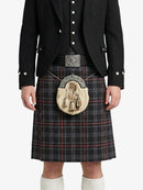 Person wearing a traditional Scottish kilt with a black jacket and white shirt on a white background