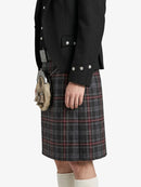Person wearing a black jacket and plaid kilt with a sporran on a white background