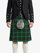Person wearing a traditional Scottish kilt with a tartan pattern on a white background