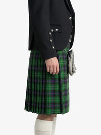 Person wearing a black jacket and green plaid kilt on a white background