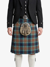 Person wearing a traditional Scottish kilt with a tartan pattern on a white background