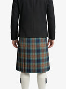 Person wearing a black jacket and plaid kilt on a white background